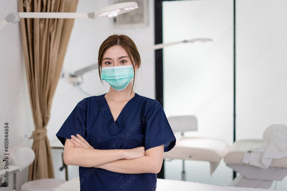 Beauty clinic and health concept. Confident woman physician Wearing protective medical mask and crossing arms on her chest posing and smile friendly with copy space for your advertising information.
