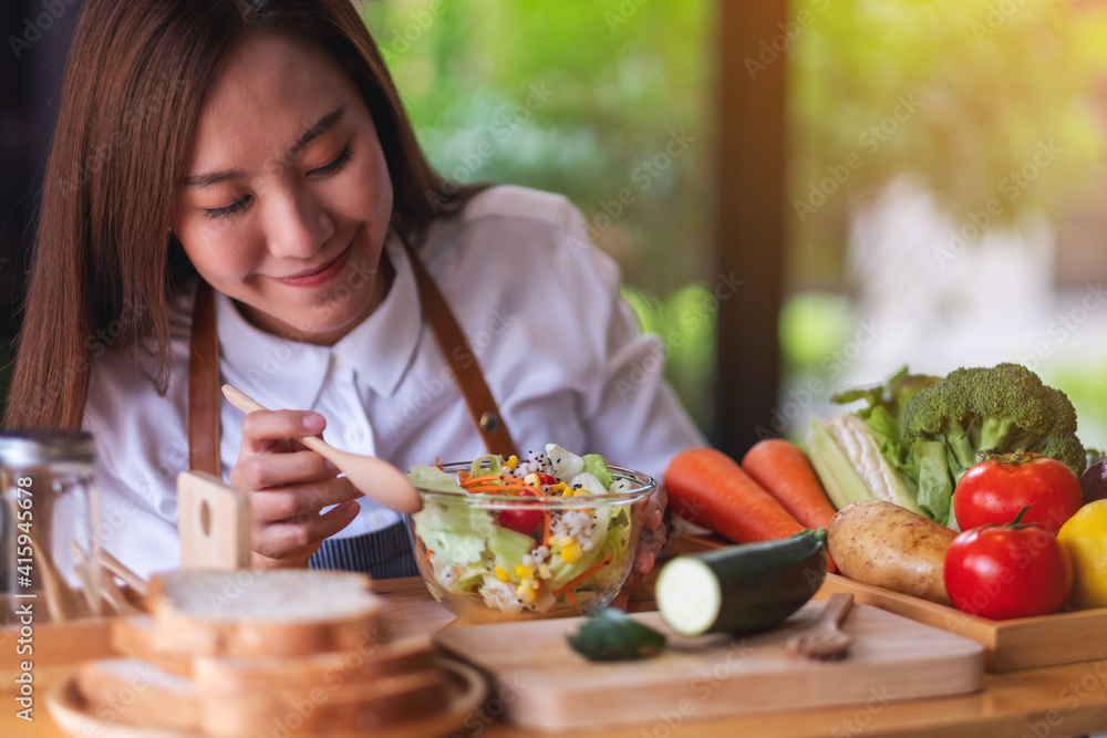 Closeup image of a female chef cooking fresh mixed vegetables salad in kitchen Closeup image of a female chef cooking fresh mixed vegetables salad in kitchen