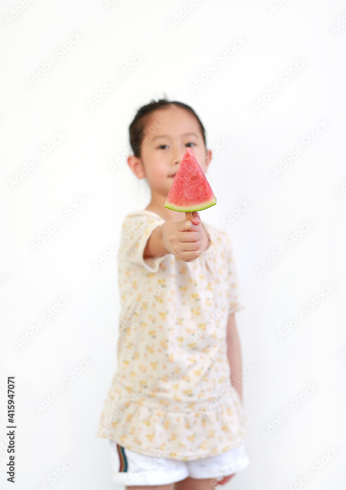 Asian little girl Showing sliced watermelon on white background. Focus at piece of watermelon in hand. Asian little girl Showing sliced watermelon on white background. Focus at piece of watermelon in hand.