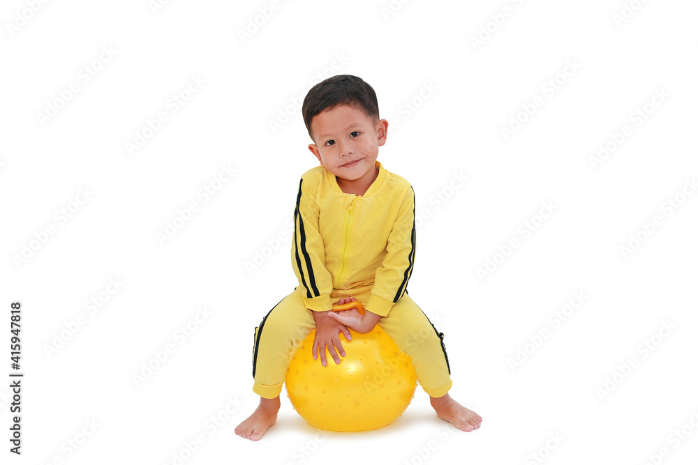Adorable Asian little baby boy playing ride and sitting on round silicone inflatable yellow knobby ball isolated on white background with clipping path Adorable Asian little baby boy playing ride and sitting on round silicone inflatable yellow knobby ball isolated on white background with clipping path