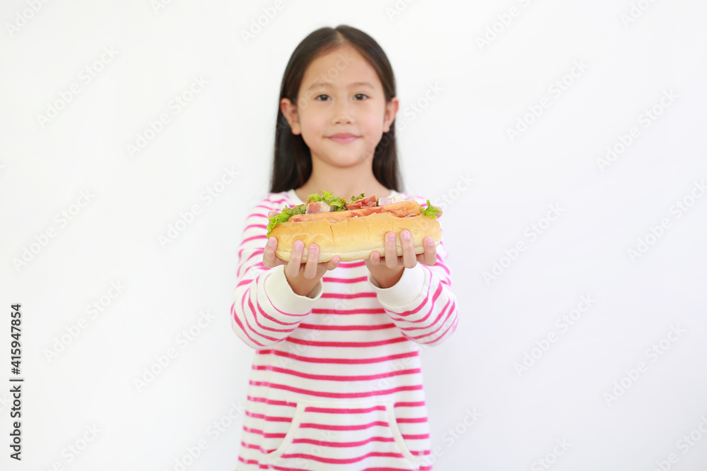 Portrait of Asian little child girl holding HOT DOG for you on white background. Focus at food on kid hands Portrait of Asian little child girl holding HOT DOG for you on white background. Focus at food on kid hands