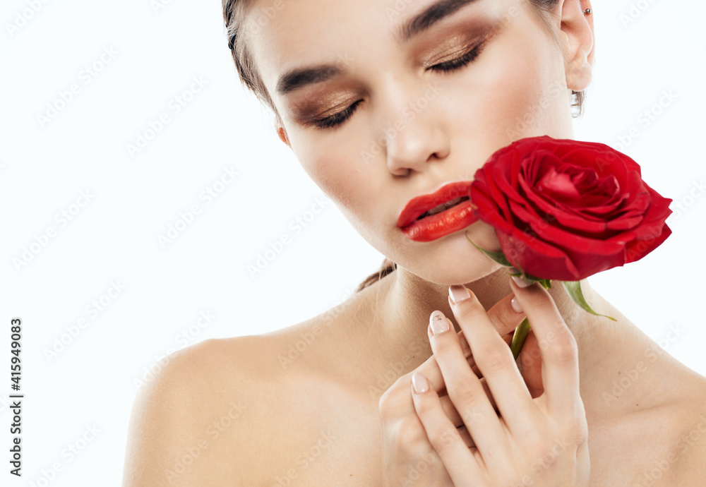 Woman with closed eyes Makeup on face and red flower naked shoulders Woman with closed eyes Makeup on face and red flower naked shoulders