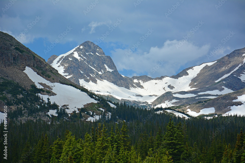 magnificent arapahoe, navajo, and shoshoni peaks with a mountain stream and snowfield on a sunny summer day along the lake isabele trail in the indian peaks wilderness area near nederland, colorado