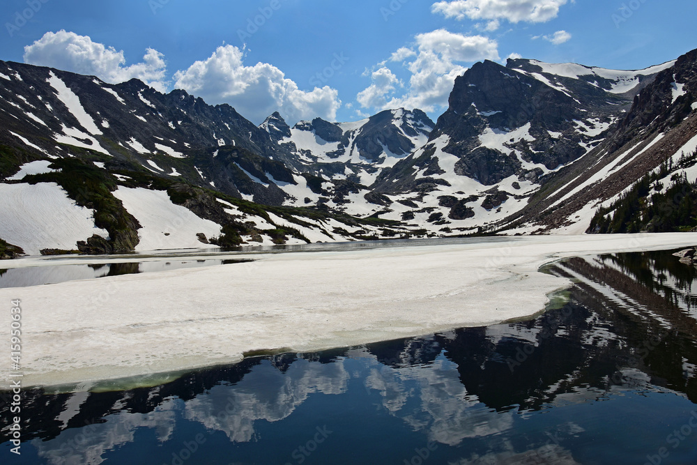 magnificent arapahoe, navajo, and shoshoni peaks at  on a sunny early  summer day at partially frozen lake isabele  in the indian peaks wilderness area near nederland, colorado