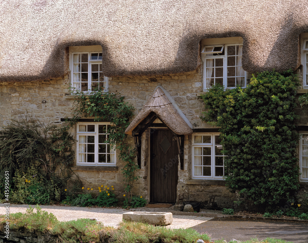 Europe, England, Buckland in the Moor. Tidy greenery enhances this thatched-roofed cottage in Buckland-in-the-Moor in Devon, England.