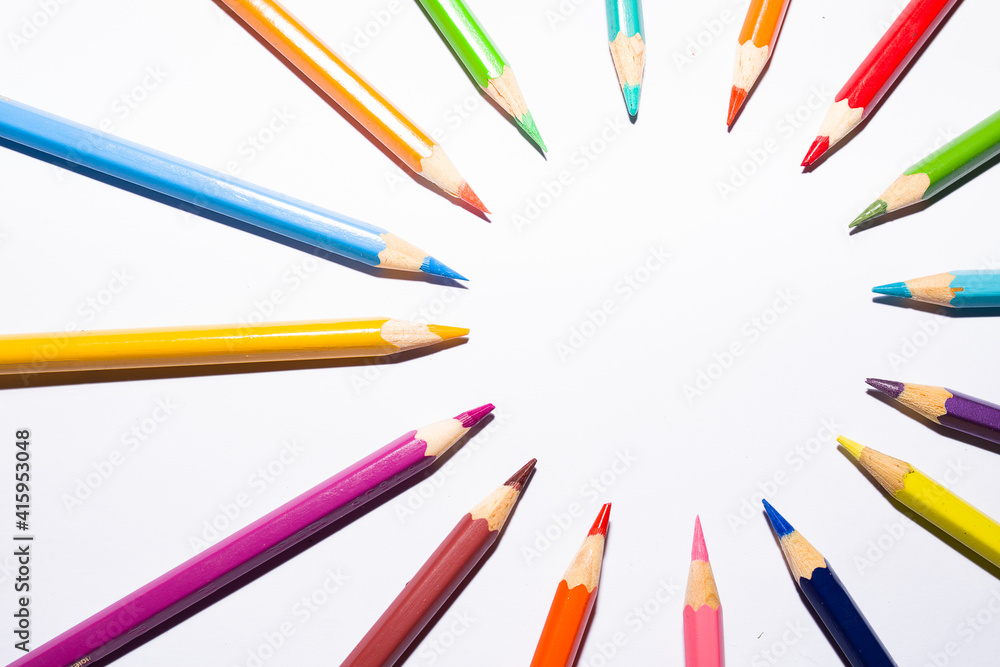 group of color pencils forming a circle on white background