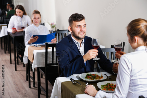 Elegant female and her boyfriend are celebrating date for dinner in luxury restaurante indoor.