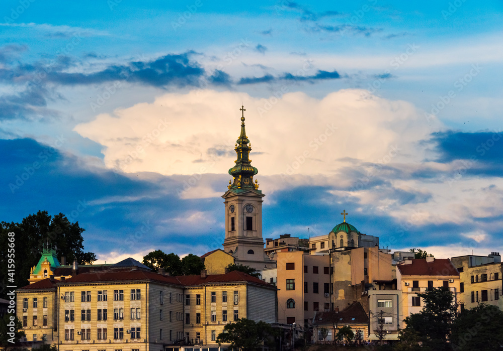 Obraz premium Saint Nicholas Church and buildings by the Danube River at sunset, Belgrade, Serbia