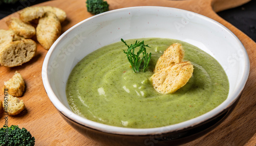 Delicious broccoli cream soup with parmesan cheese and crunchy croutons. Healthy vegetarian food. Vegan menu. Top view, copy space