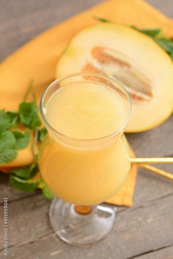 Glass with melon smoothie on wooden background Glass with melon smoothie on wooden background