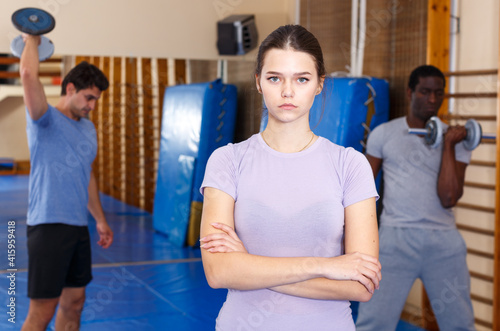 Portrait of confident athletic young woman standing at fitness center