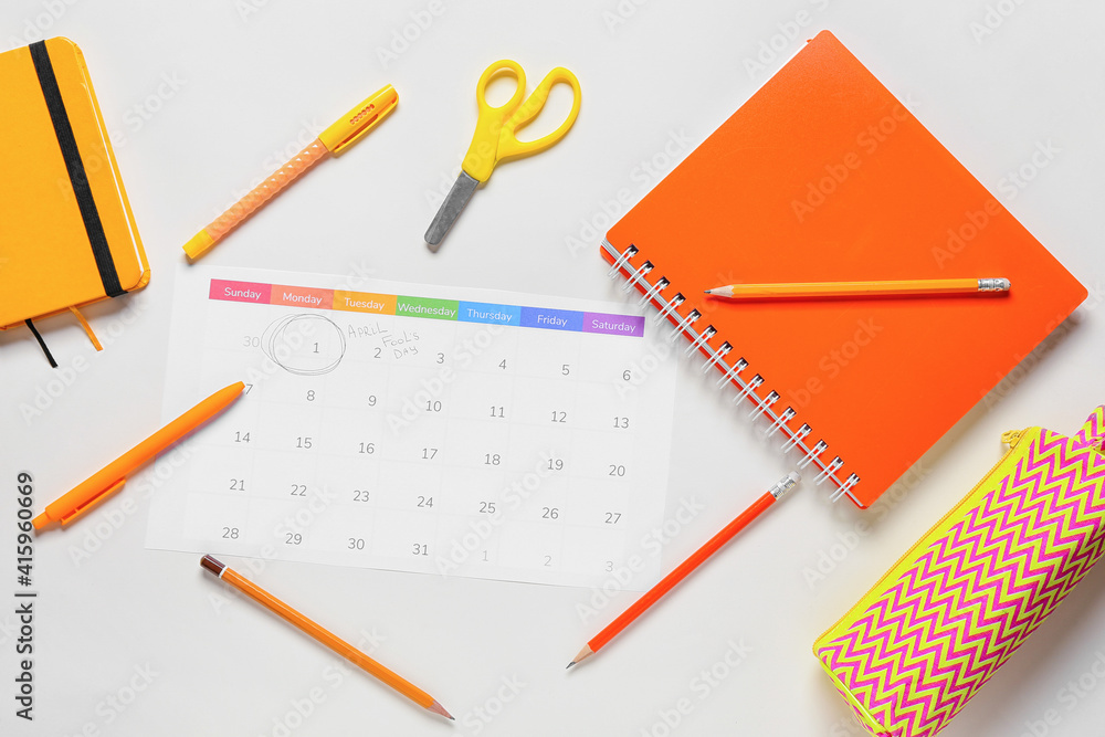 Calendar with marked date of April Fool's Day and stationery on light background Calendar with marked date of April Fool's Day and stationery on light background