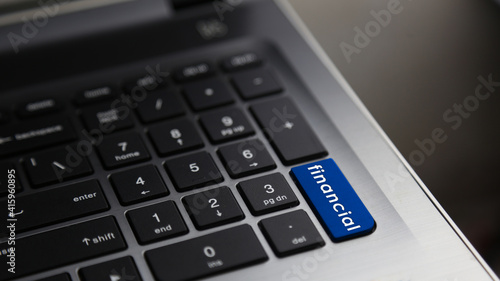 Financial word on laptop keyboard blue button. Concept for business and financial.