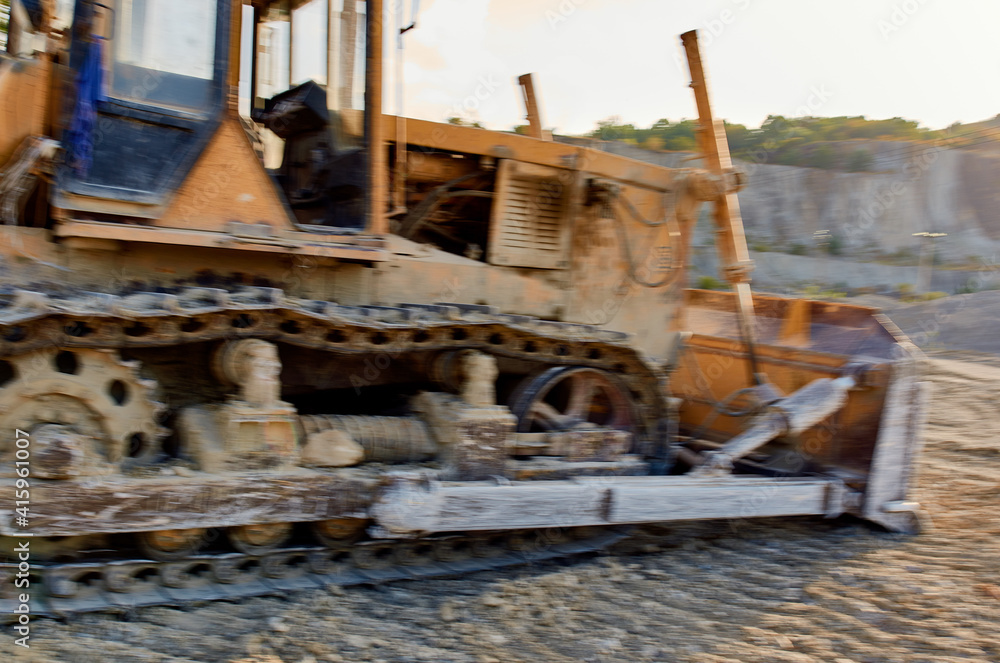 Fototapeta premium yellow excavator digs the ground in nature and sun summer sand