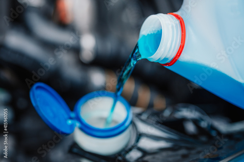 Pouring antifreeze. Filling a windshield washer tank with an antifreeze in winter cold weather. photo