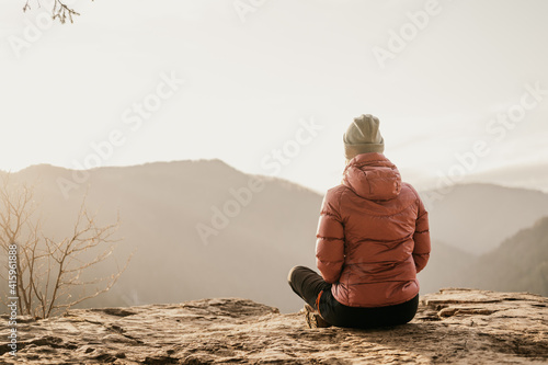 Fotobehang Woman enjoying the sunset in nature on the edge of a rock cliff