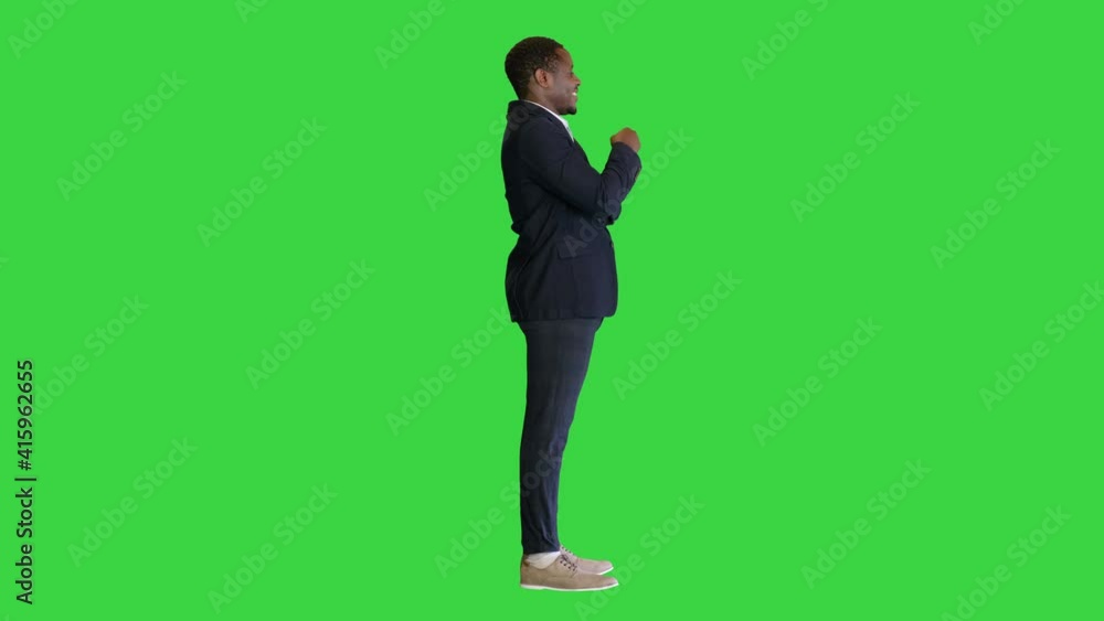 Black businessman with crossed arms pointing a finger on a Green Screen, Chroma Key. Black businessman with crossed arms pointing a finger on a Green Screen, Chroma Key.