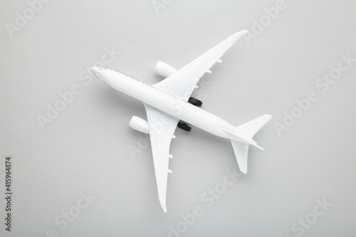 Model white airplane on a grey background.