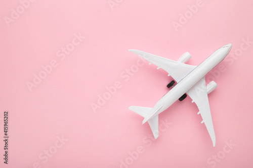 Model airplane on pink pastel color background.