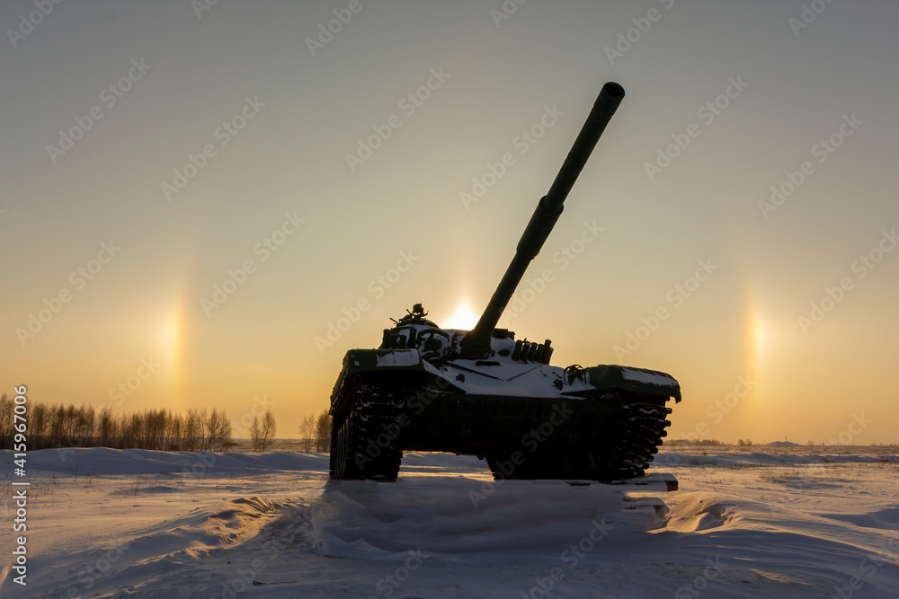 Modern military tank on the background of a solar halo effect. The concept of reducing the world arms race.