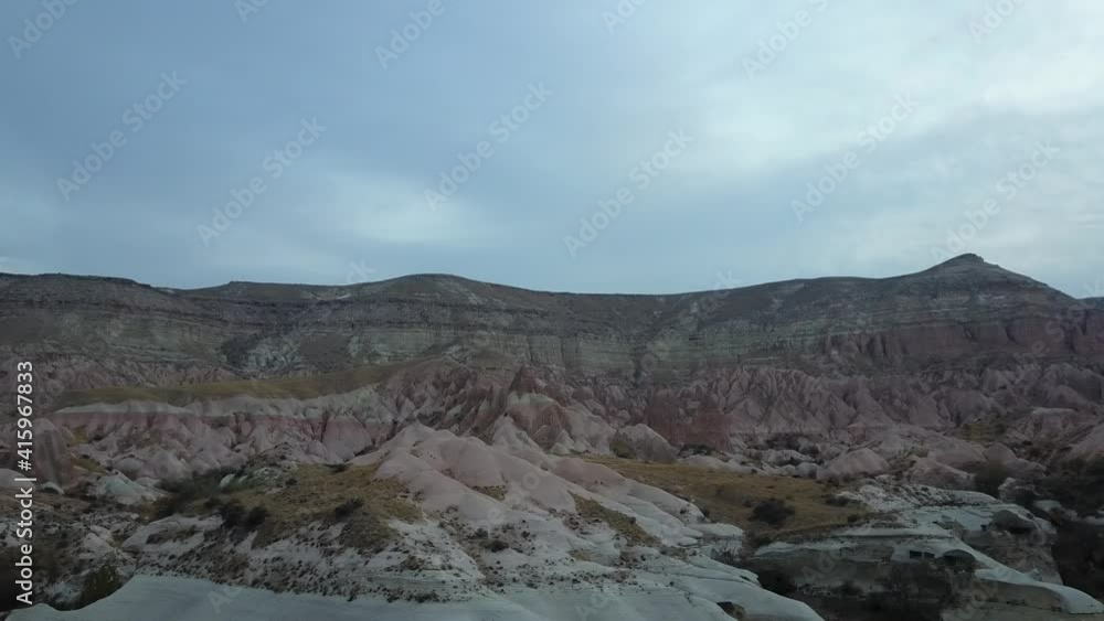 Aerial Side View Colorful Painted Red Rock Canyon Desert Landscape Rose Valley Cappadocia Turkey Gloomy Winter Morning (Drone - 4K) Aerial Side View Colorful Painted Red Rock Canyon Desert Landscape Rose Valley Cappadocia Turkey Gloomy Winter Morning (Drone - 4K)