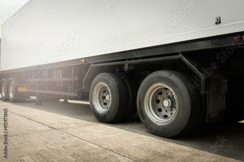 Cargo trailer truck with a big truck wheels and tires. Semi truck, Lorry. Industry cargo freight truck transportation.