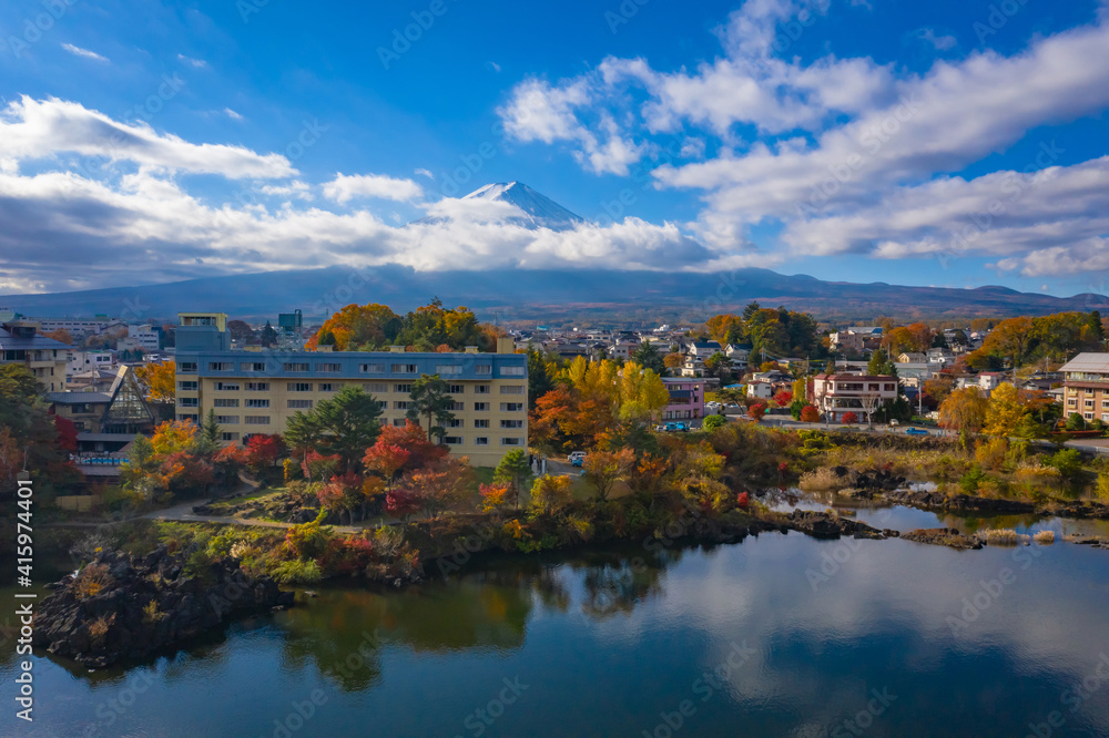 Fujiyama in Japan. Lake Kawaguchiko in autumn. Autumn landscape of Fujikawaguchiko city. Mount Fuji is visible behind the clouds. A bird's eye view of Japan city. Travel to Mount Fujiyama.