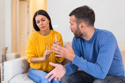 Fotografija Stressed young married family couple arguing emotionally, blaming lecturing each other, sitting on couch