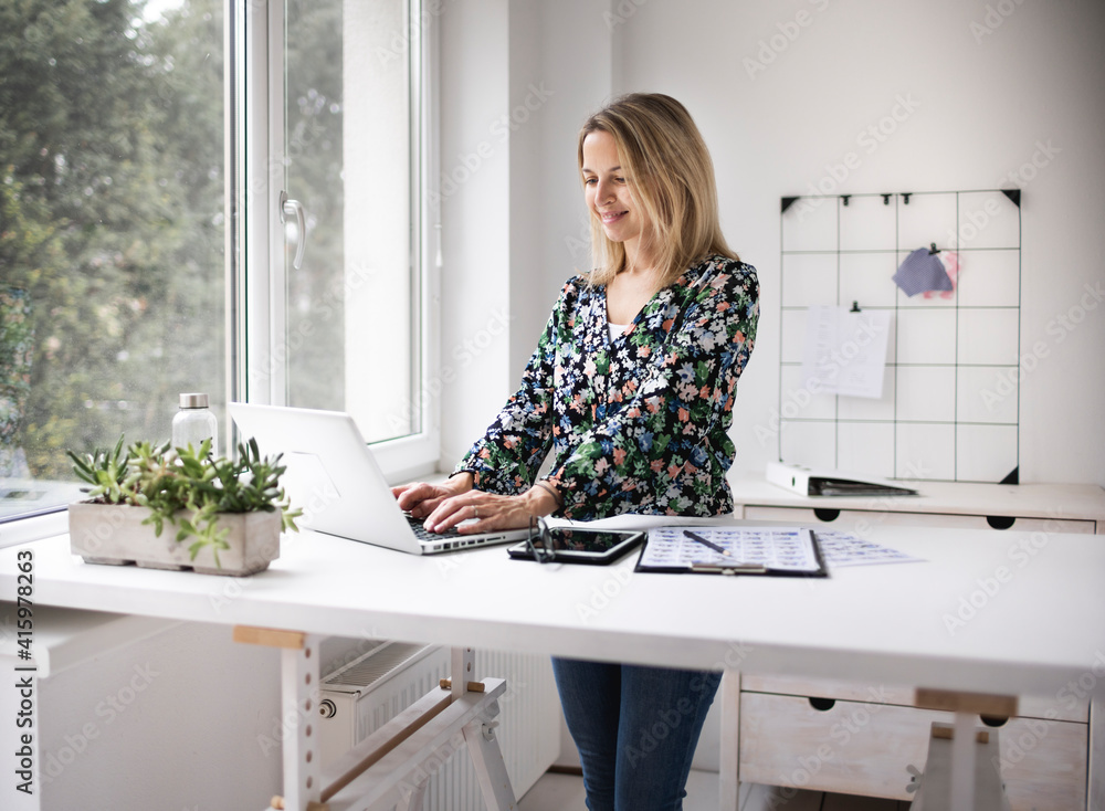 Businesswoman working at ergonomic standing desk. Businesswoman working at ergonomic standing desk.