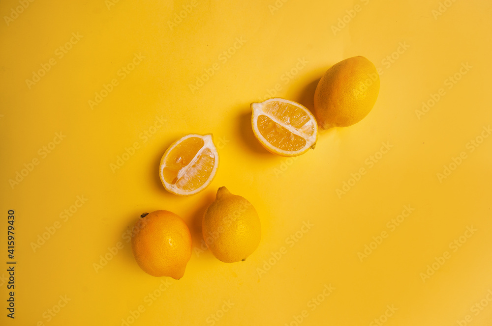Fototapeta Yellow fruits on yellow background lemons copy space pantone 2021 beautiful juicy colorful