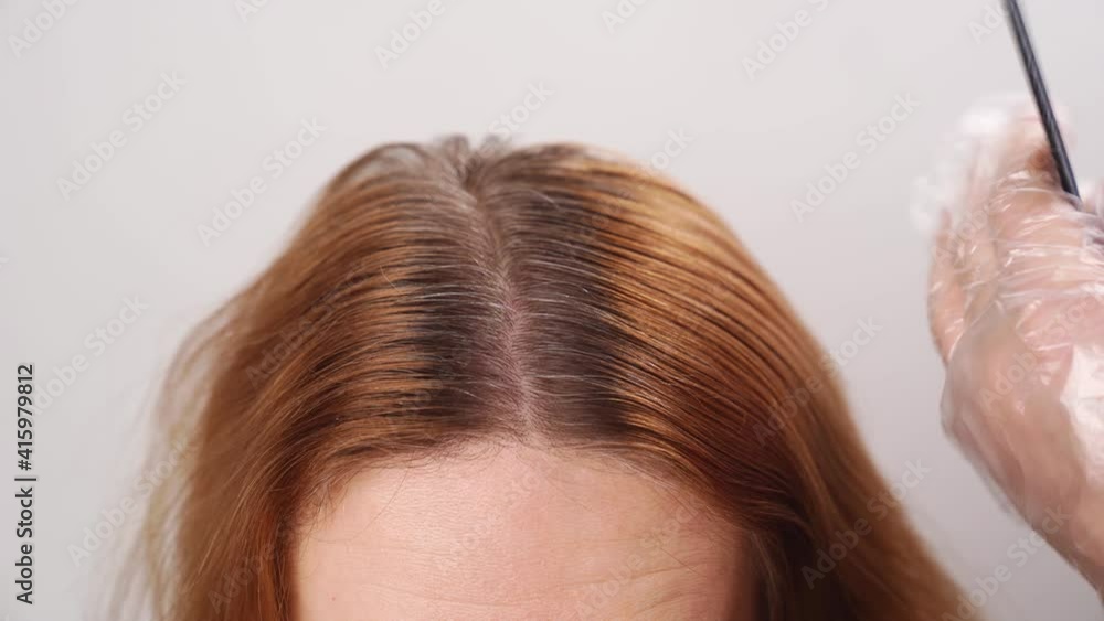 self-coloring the gray roots of hair on the head of a woman. beauty salon and hairdresser. self-coloring the gray roots of hair on the head of a woman. beauty salon and hairdresser.