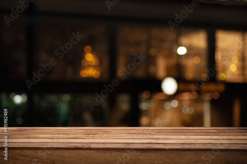 empty table to showcase your product  against the background of a blurred cafe golden bokeh