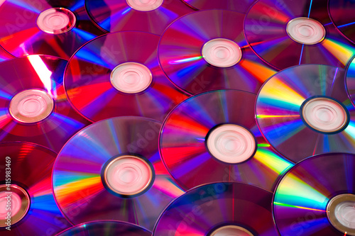 Background CD and DVD discs laid out on a flat surface. Background for saving information. Abstraction. #415983469