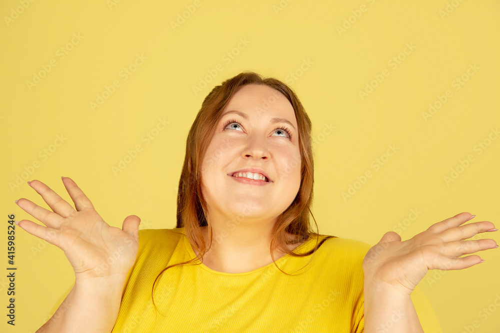 Close up, dreamy. Beautiful plump caucasian plus size model isolated on yellow studio background. Concept of inclusion, human emotions, facial expression, sales, body positive. Copyspace for ad. Close up, dreamy. Beautiful plump caucasian plus size model isolated on yellow studio background. Concept of inclusion, human emotions, facial expression, sales, body positive. Copyspace for ad.