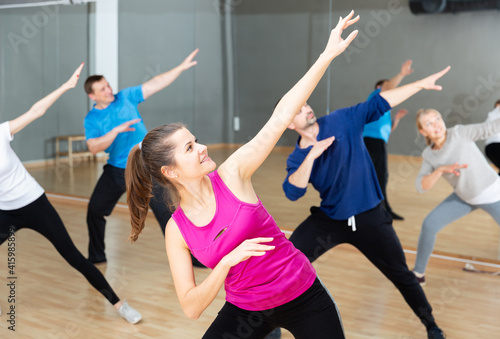 Cheerful young woman enjoying active dances in modern dance studio.