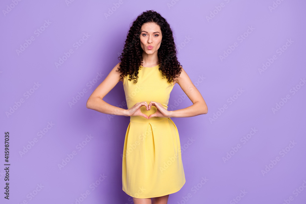Portrait of adorable curly hairstyle young girl lips kiss fingers show heart symbol isolated on purple color background Portrait of adorable curly hairstyle young girl lips kiss fingers show heart symbol isolated on purple color background