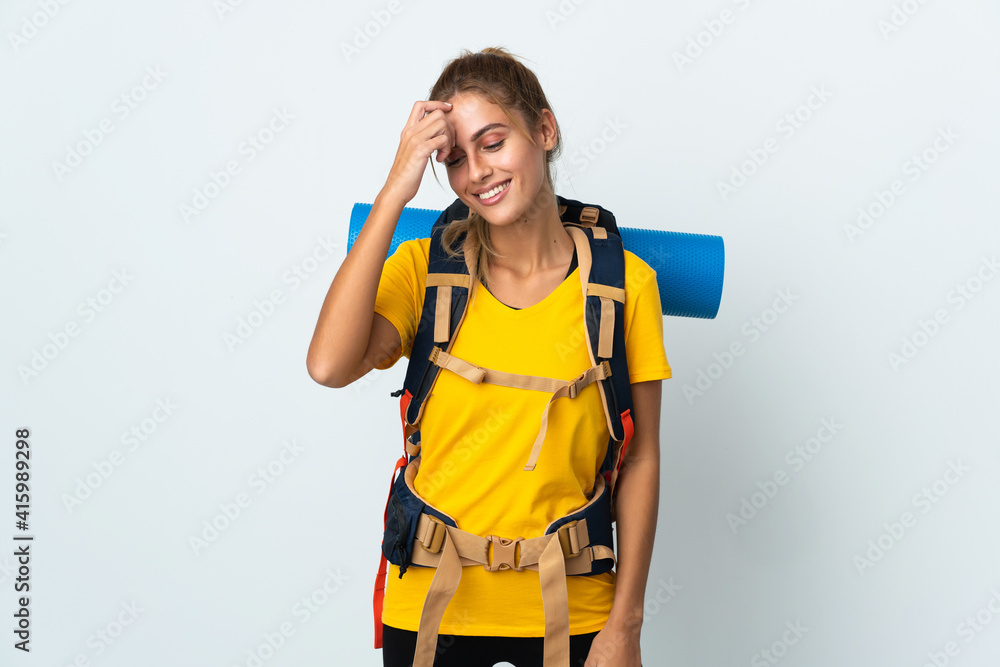 Young mountaineer woman with a big backpack isolated on white background laughing Young mountaineer woman with a big backpack isolated on white background laughing