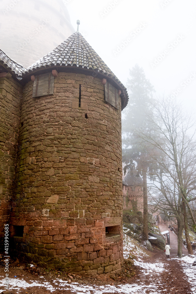 Tour de la façade ouest du château alsacien du Haut-Koenigsbourg, sous la neige et la brume en hiver, Alsace, France