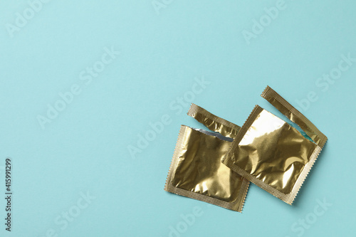 Empty blank condom packagings on blue background