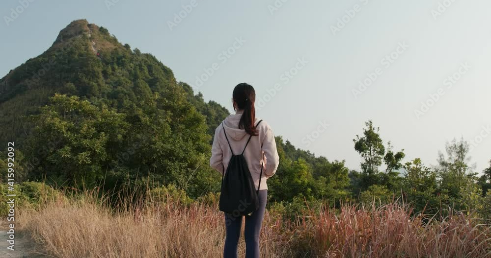 Woman look at the mountain and prepare to hike Woman look at the mountain and prepare to hike