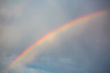 rainbow over blue sky with clouds
