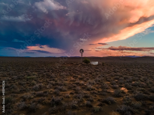 Aerial view of Karoo windmill and dirt road at sunset after thunderstorm, N12 highway, South Africa photo