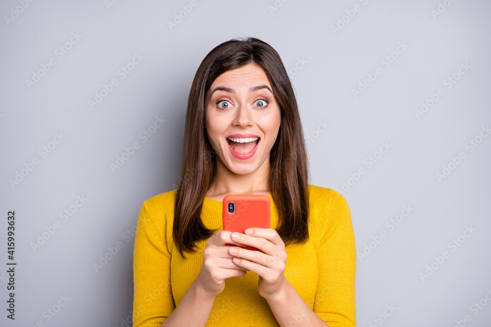 Photo of impressed brunette nice lady hold telephone wear yellow sweater isolated on grey color background Photo of impressed brunette nice lady hold telephone wear yellow sweater isolated on grey color background