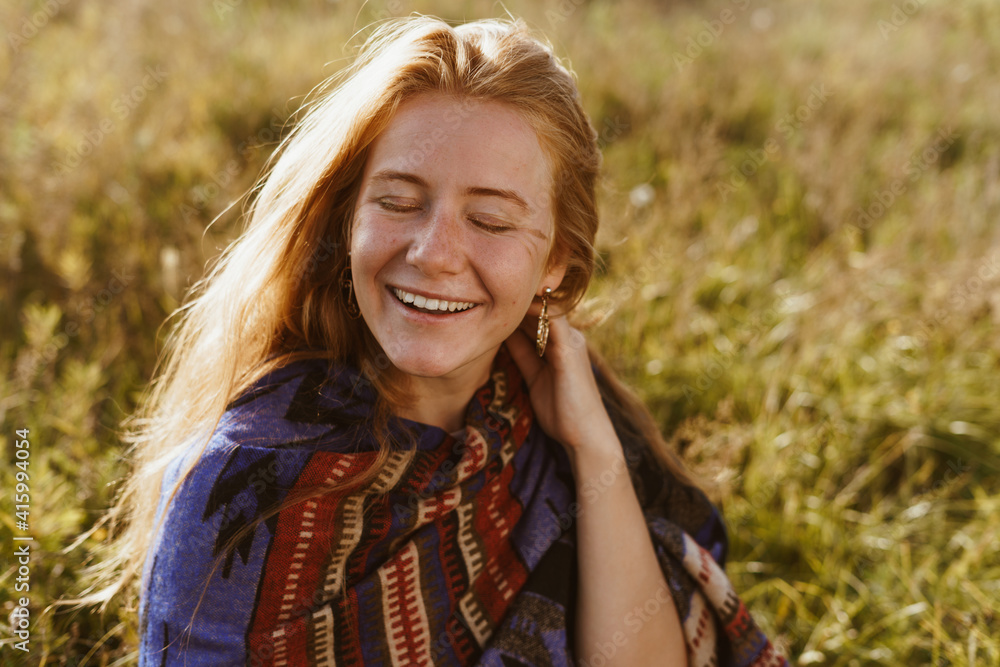In the style cape ethno sits a smiling girl covering her eyes gleefully laughing. High quality photo In the style cape ethno sits a smiling girl covering her eyes gleefully laughing. High quality photo