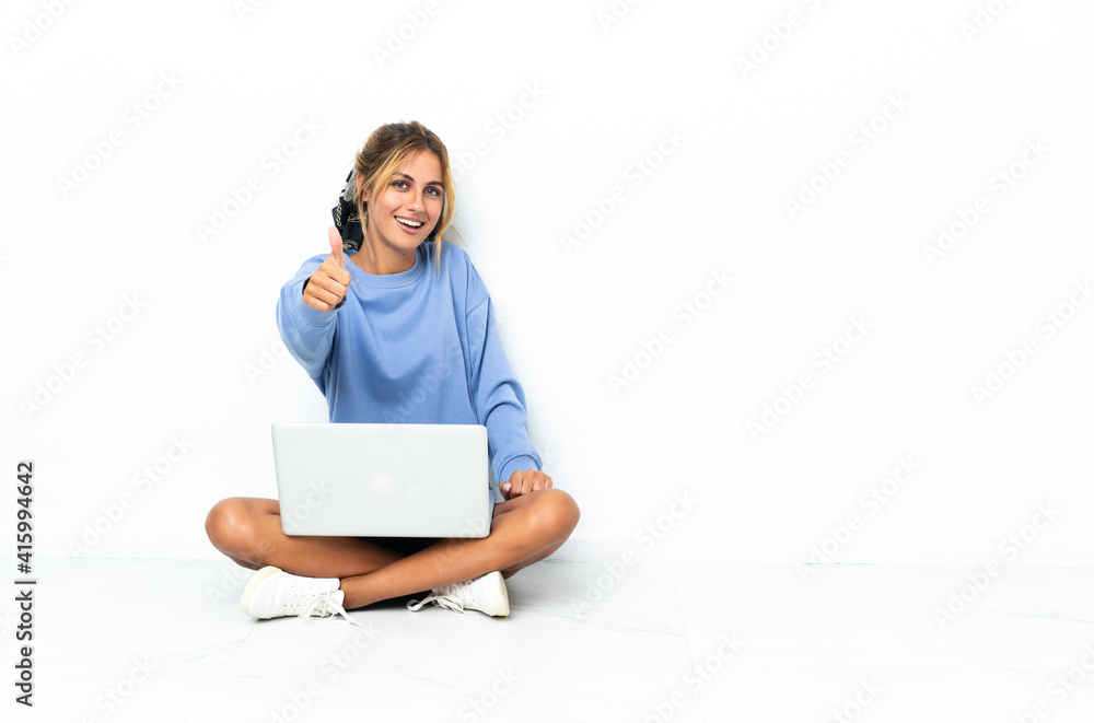 Young blonde Uruguayan girl with the laptop isolated on white background with thumbs up because something good has happened Young blonde Uruguayan girl with the laptop isolated on white background with thumbs up because something good has happened