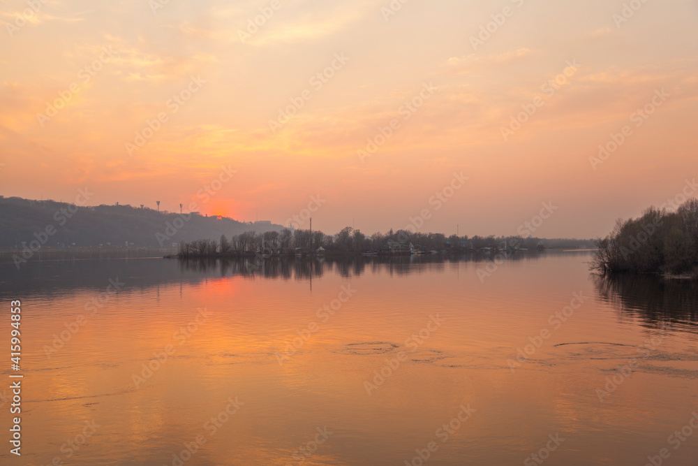 Sunset on the river. Cityscape with evening river and pink sunset