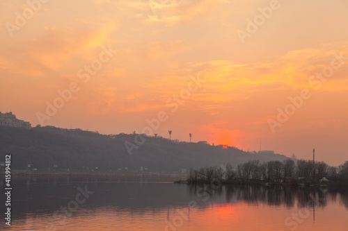 Sunset on the river. Cityscape with evening river and pink sunset