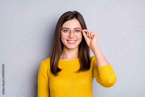 Portrait of pretty cheerful content girl touching specs good healthy vision isolated over grey color background photo