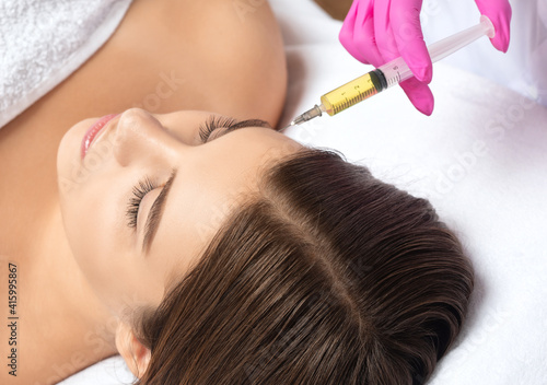 Cosmetologist does prp therapy on the face of a beautiful woman in a beauty salon. Female aesthetic cosmetology in a beauty salon.