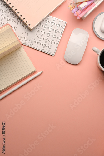 Pink creative study table with computer keyboard, mouse, stationery and copy space